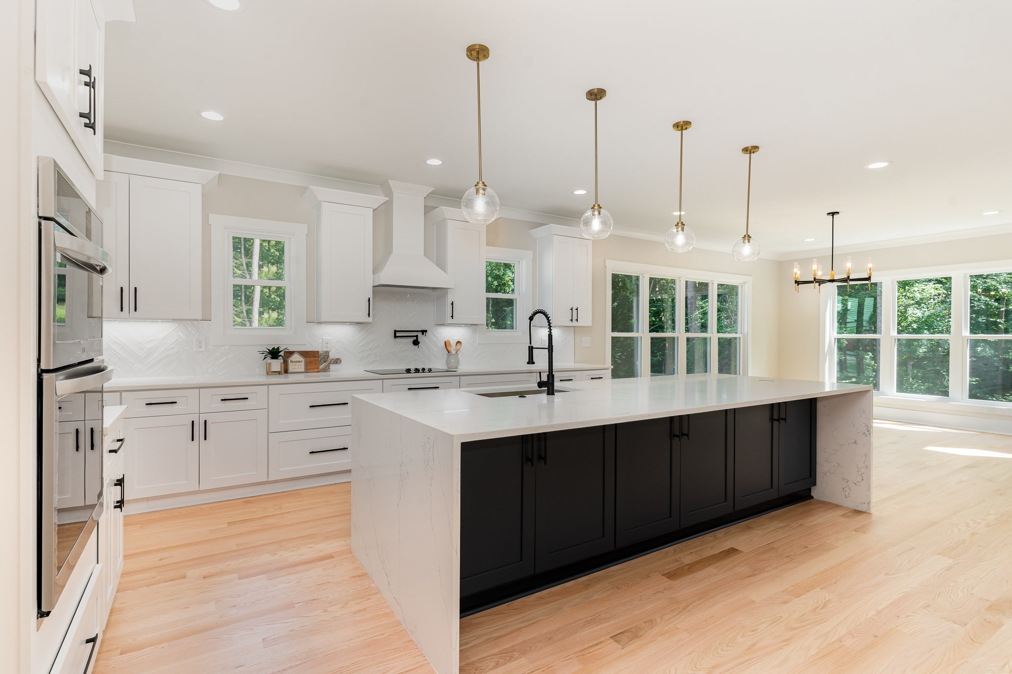 Custom home kitchen with large island and white cabinetry