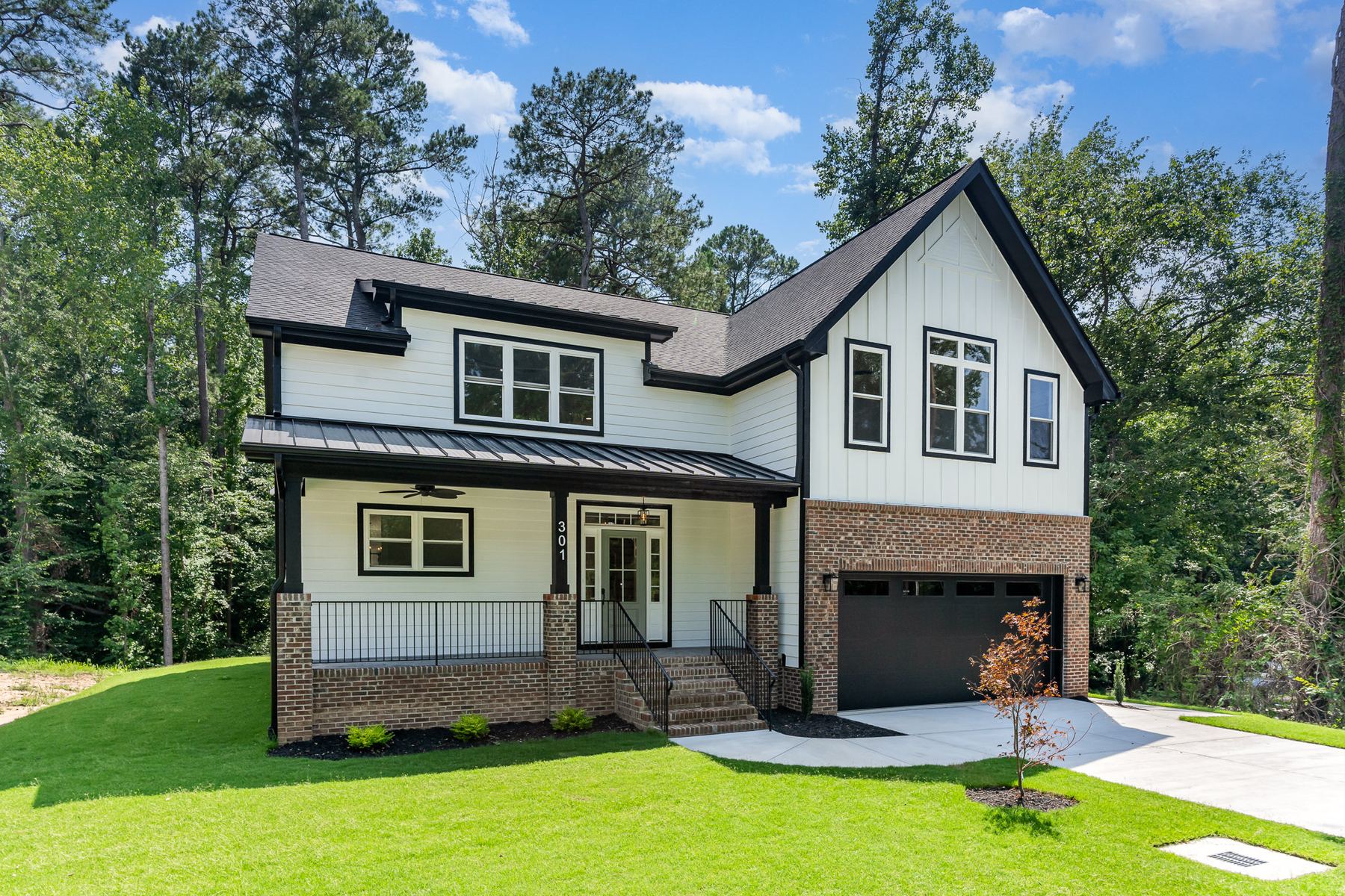 Finished modern farmhouse exterior with board-and-batten siding and brick